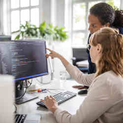 Women consulting on a software development project.