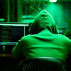 Hooded ransomware criminals works on computers to commit data attacks.