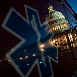 The U.S. Capitol dome reflected in the window of a medical vehicle.