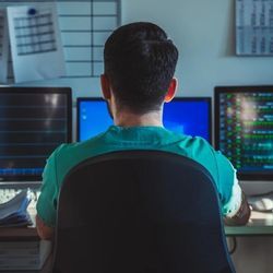 A doctor checks patient info at a computer workstation.