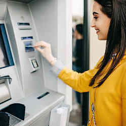 A woman uses an ATM. 