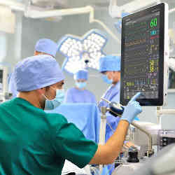 A doctor on a surgical team consults computerized technology.