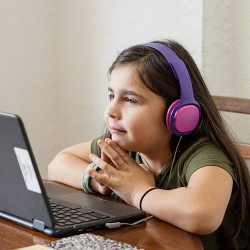 a girl in headphones reads from a laptop computer