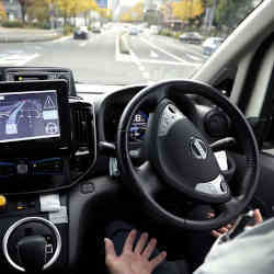 A safety driver behind the wheel of a Nissan robotaxi.