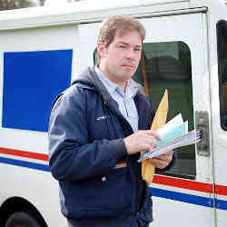 A letter carrier delivering snail mail.