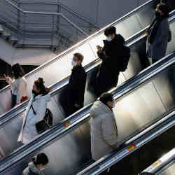 People wearing masks ride on an escalator in a subway station during the coronavirus (COVID-19) pandemic, in Seoul, South Korea, December 8, 2021. REUTERS/Heo Ran  People wearing masks ride on an escalator at a subway station, amid the coronavirus disease