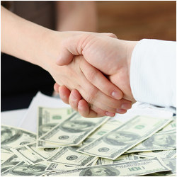 handshake and dollars suggesting business transaction