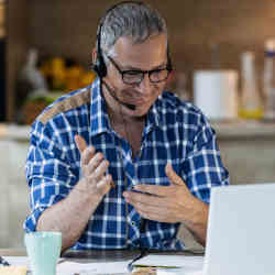 A man controls his laptop with hand gestures. 