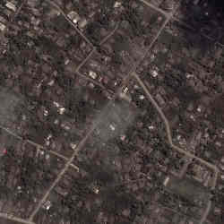 A satellite image shows ash-covered homes and buildings in Tonga. 