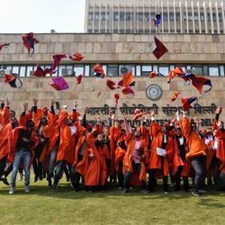 Indian tech graduates toss their caps in the air.