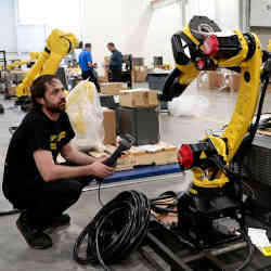 A technician prepares a manufacturing robot for shipping to a customer in a FANUC American facility in Auburn Hills, MI.