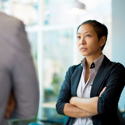 worker with folded arms stares at another person