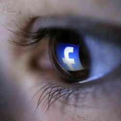 The Facebook logo reflected in an eye.