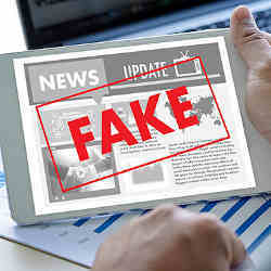 Item on a tablet computer is labelled Fake News. 