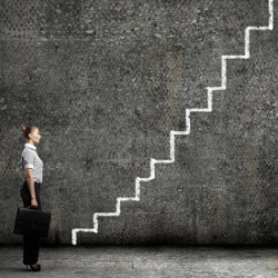 businesswoman at the foot of a drawn staircase