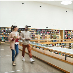 students walking through a college library