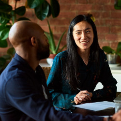 male and female co-workers in discussion seated at a table