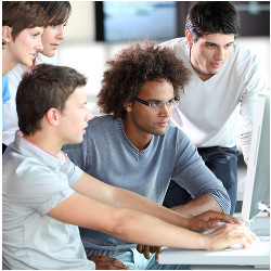 young workers huddle around a computer display