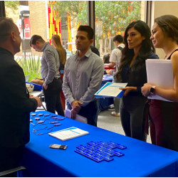 job seekers listen to a recruiter at a career fair