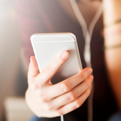 woman in earphones holding a mobile phone