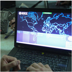 hands on keyboard of laptop computer with display showing a world map