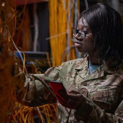 Army technician works on tablet in a data center.