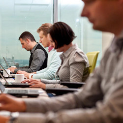 workers typing on keyboards in a workplace