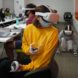 University of Miami student wearing an Oculus Quest 2 headset and operating hand controls