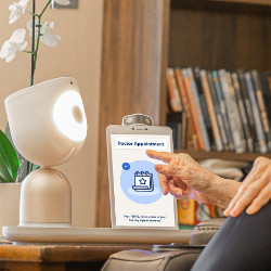 elderly hands interact with the ElliQ robot