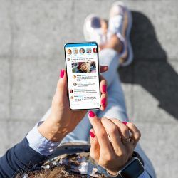 A person uses a social media app on a smartphone.