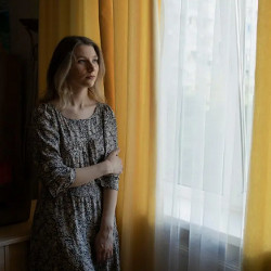 Daryna Hameliak of Avenga stands at a curtained window