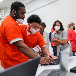 students from Brave Behind Bars interact with laptop computers