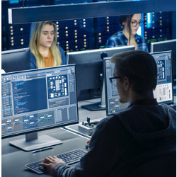 workers at computers in data center system control room