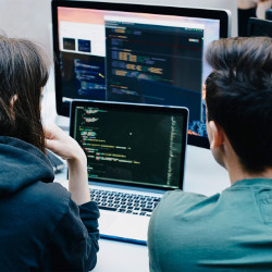 two workers at a laptop computer