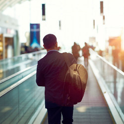 Asian businessman on airport escalator