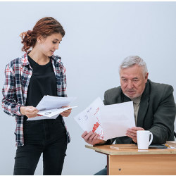 student and an older teacher examine papers