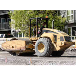 A vibratory roller compacts a road bed.