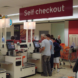 shoppers using self-checkout lanes at a retailer