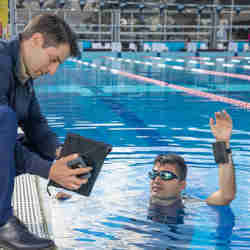 A swimmer wears the APPTRAKK module on his wrist.