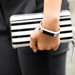 fashionable Fitbit device on the wrist of a woman holding a purse