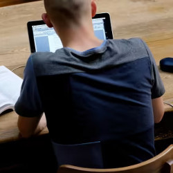 student in library working at a laptop computer