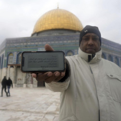 man holding a mobile phone in the Al-Aqsa Mosque compound of the Old City of Jerusalem