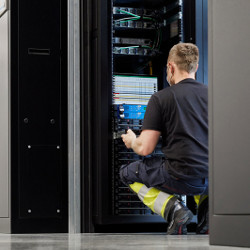 worker examines a server system at Apple's data center in Viborg, Denmark