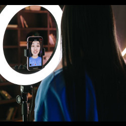 virtual influencer looks into a round, lighted mirror