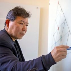 Shang-Hua Teng professor of computer science at USC, demonstrating a theorem on a white board.