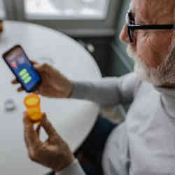A senior trying to renew a prescription with his smartphone. 