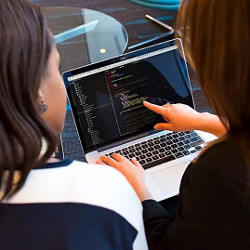 two women working at a laptop computer