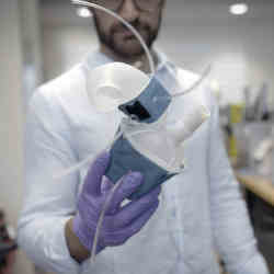A doctor holds a custom-made robotic heart.