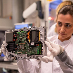 A technician checks a DC/DC half-bridge converter at a Continental production facility