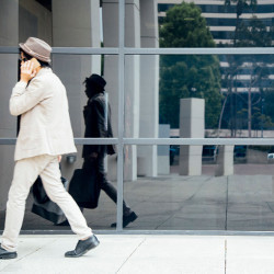 young man walking past an office building